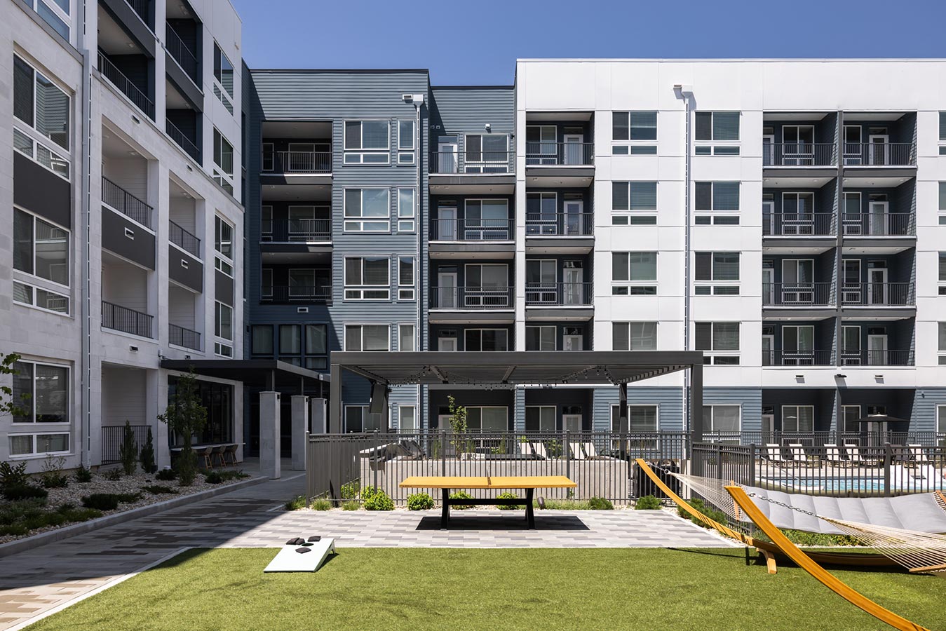 View of Rye Central Park from outside pool area with cornhole and hammocks