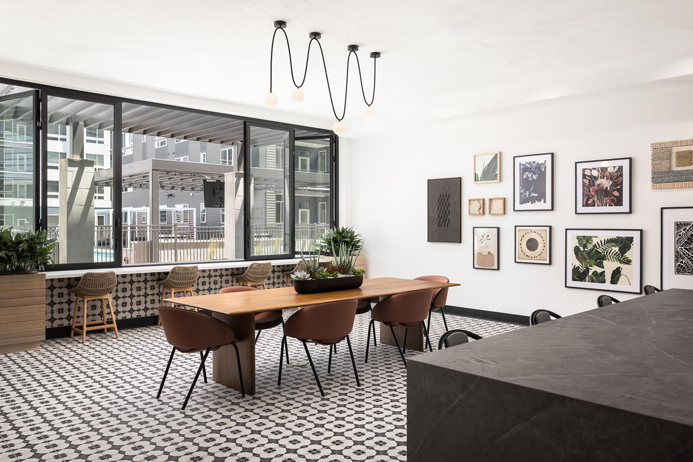 Clubhouse area with table and stools to host with pool view