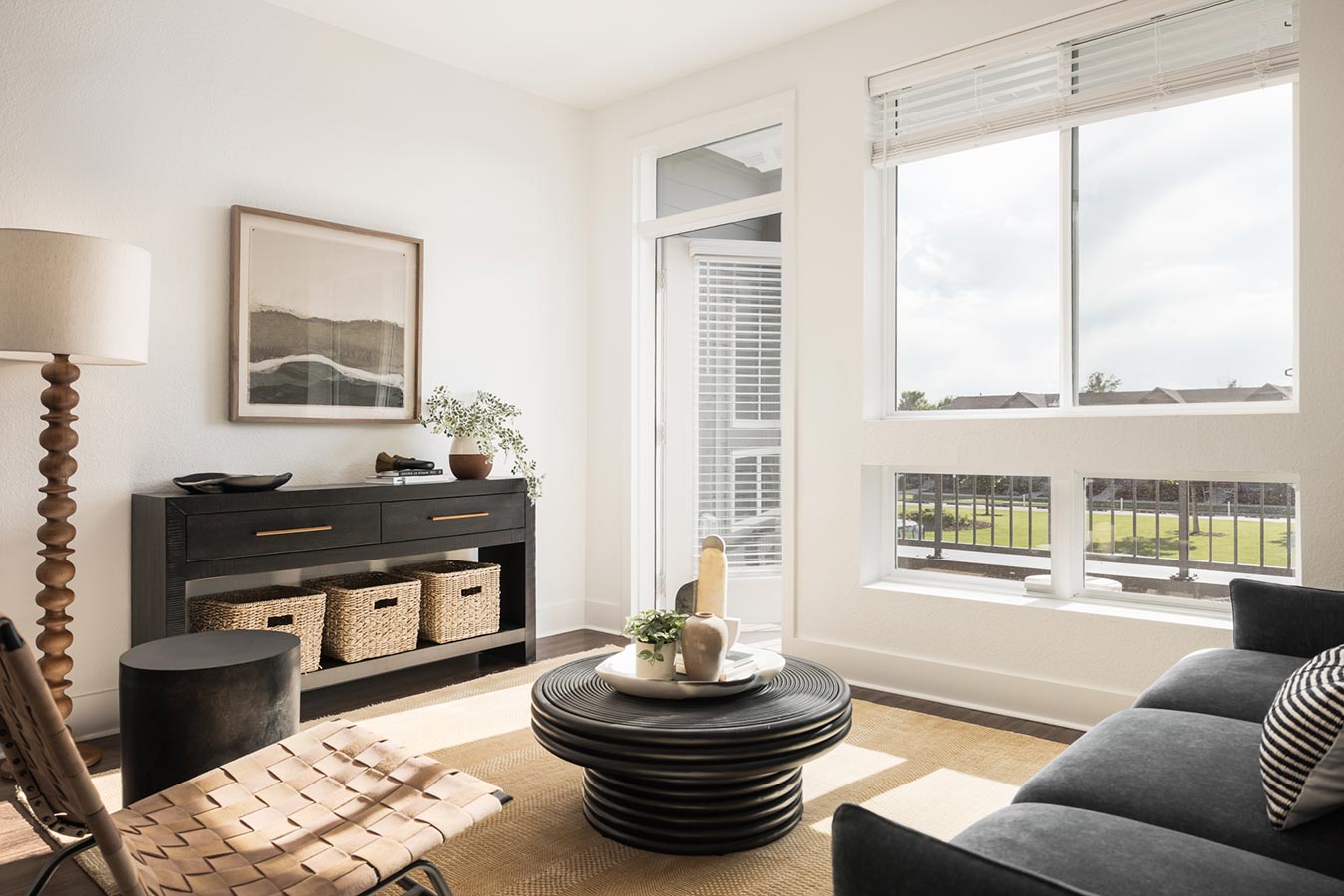 Living room with floor to ceiling windows and open door to balcony